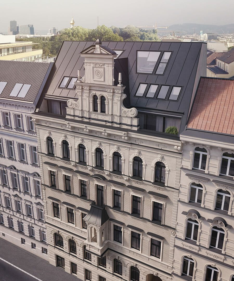 Luftaufnahme eines klassischen Gebäudes im europäischen Stil mit verschnörkelter Fassade und modernen Dachfenstern.